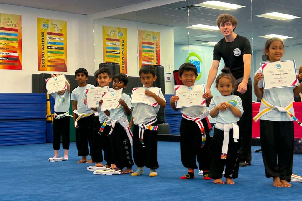 Children at Kung Fu Kids show off their new graduation certificates