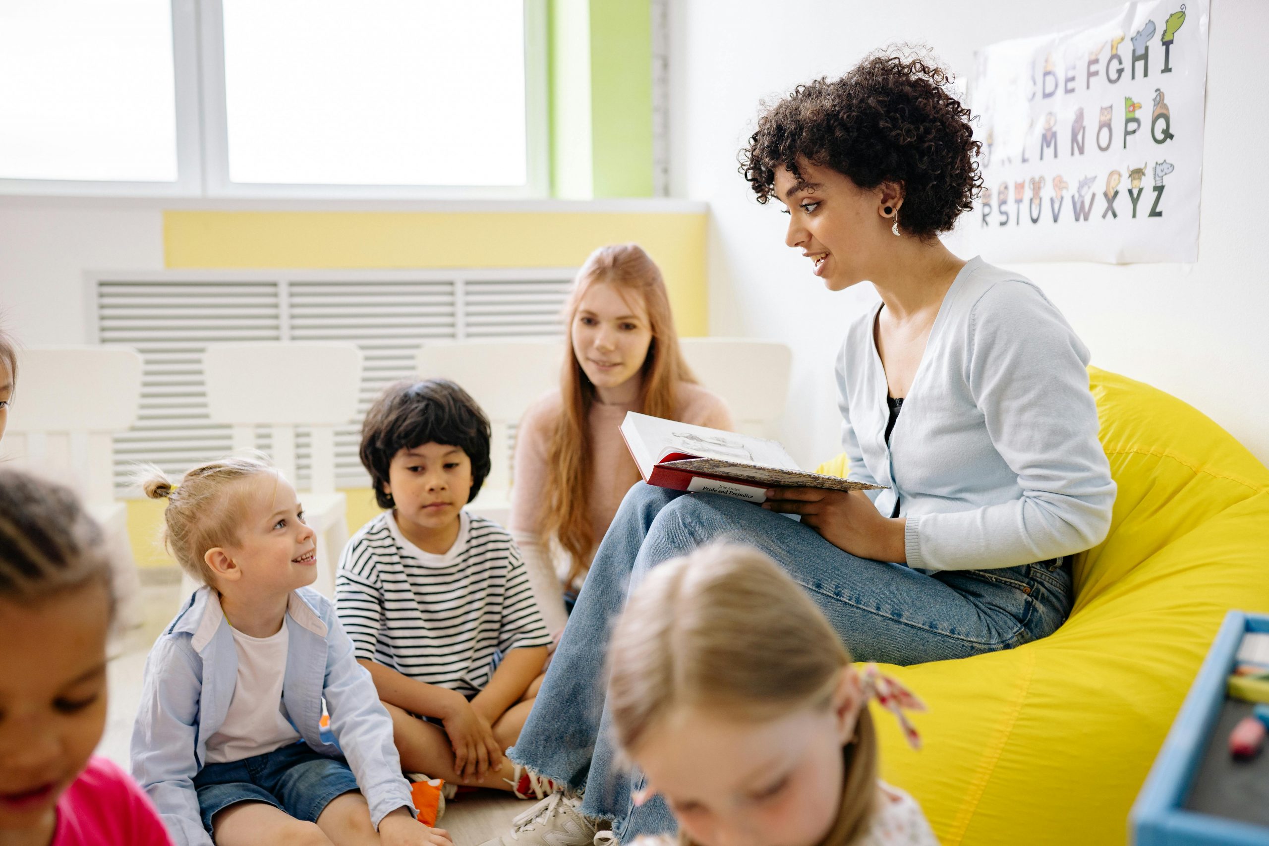 a school teacher reading to a group of young children